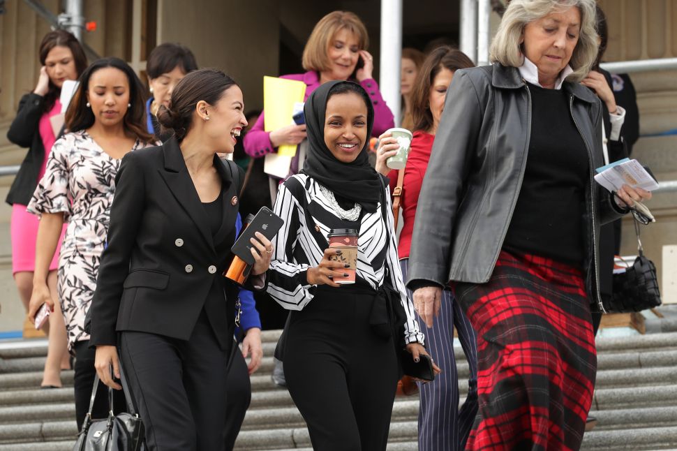 Rep. Alexandria Ocasio-Cortez (D-N.Y.) (L) and Rep. Ilhan Omar (D-Minn.) (C) join their fellow House Democratic women for a portrait in front of the U.S. Capitol.