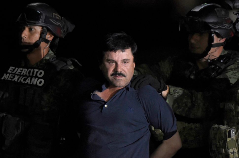 Drug kingpin Joaquin "El Chapo" Guzman is escorted into a helicopter at Mexico City's airport on January 8, 2016 following his recapture during an intense military operation. 