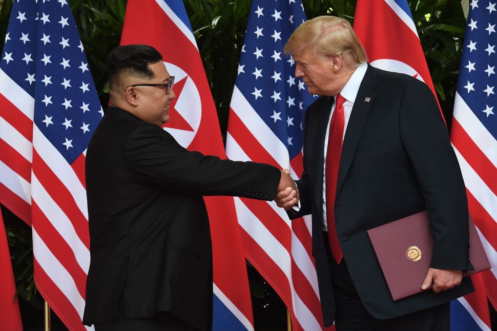 North Korea's leader Kim Jong-un shakes hands with President Donald Trump.