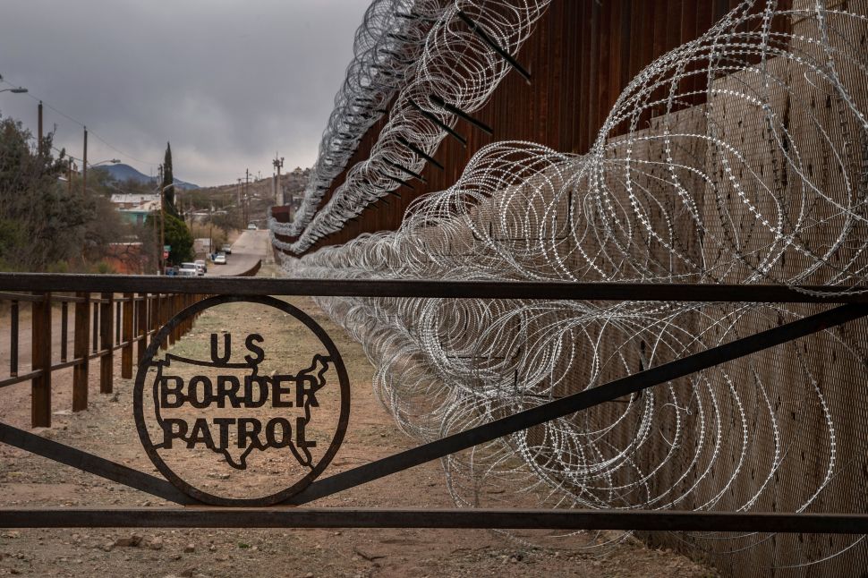 A metal fence marked with the U.S. Border Patrol sign prevents people to get close to the barbed/concertina wire covering the U.S.-Mexico border fence, in Nogales, Ariz., on February 9, 2019.