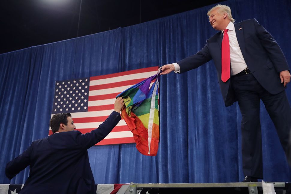 Then-presidential nominee Donald Trump returns an LGBTQ rainbow flag given to him by a supporter.