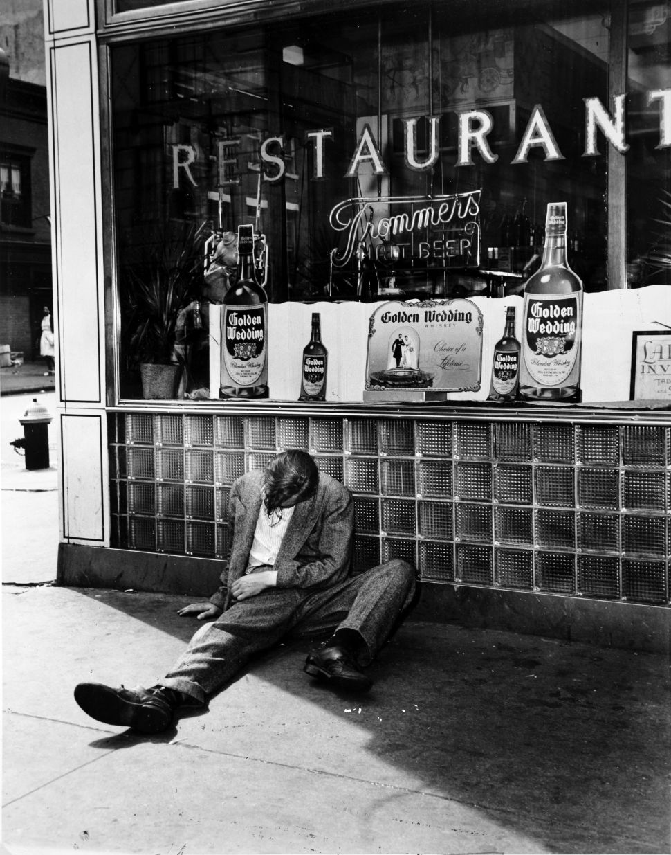 A man sits collapsed in a drunken stupor outside a licensed restaurant.