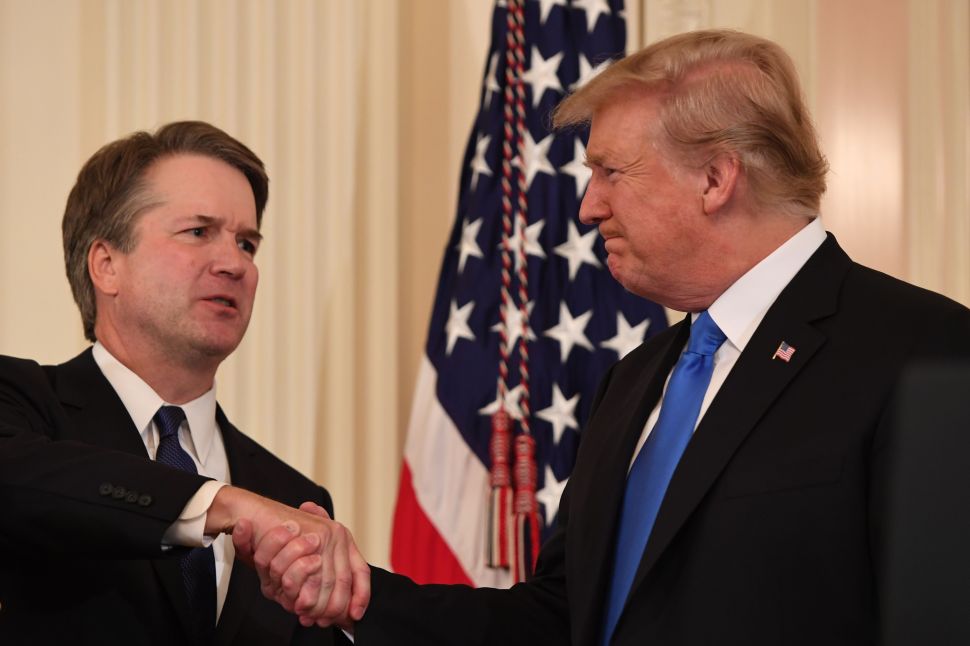Judge Brett Kavanaugh (L) shakes hands with U.S. President Donald Trump after being nominated to the Supreme Court.