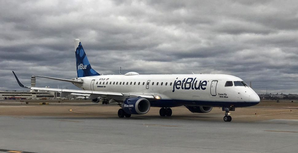 A JetBlue airplane sits on the tarmac waiting for take off.