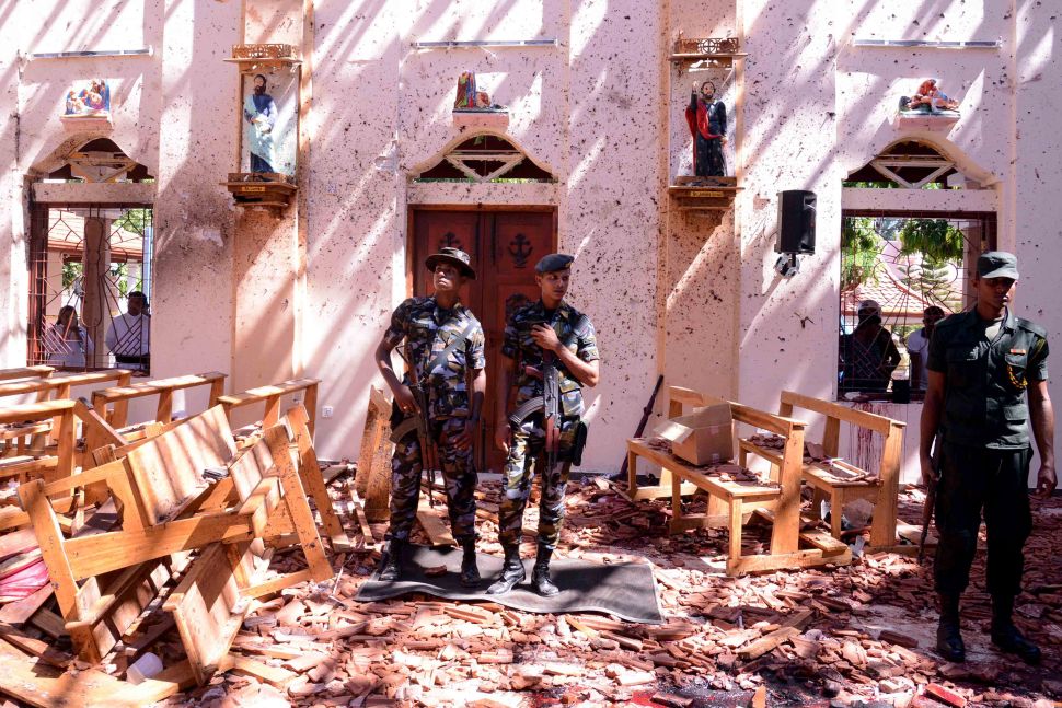 Sri Lankan soldiers look on inside the St Sebastian's Church at Katuwapitiya in Negombo on April 21, 2019, following a bomb blast during the Easter service that killed tens of people. A series of eight devastating bomb blasts ripped through high-end hotels and churches holding Easter services in Sri Lanka, killing nearly 160 people, including dozens of foreigners.