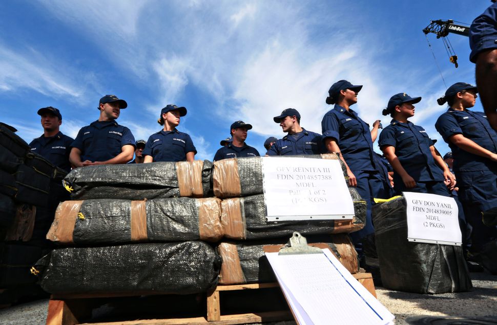 U.S. Coast Guardsmen stand aboard the Cutter Boutwell with piles of confiscated cocaine, seized during 18 different interdictions off the coast of Central and South America, on October 6, 2014 in San Diego, California.