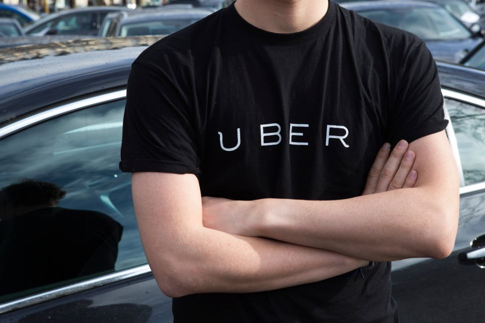 A protester wears a shirt displaying the logo of smartphone ride service Uber during by a protest.