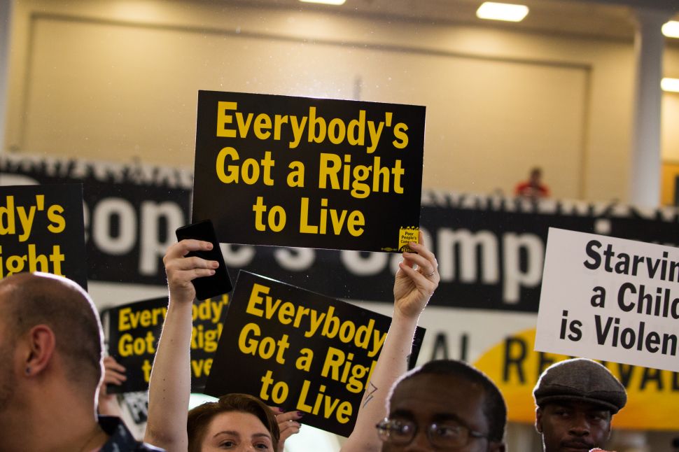 Attendees hold signs at the Poor People's Moral Action Congress at Trinity University in Washington D.C.