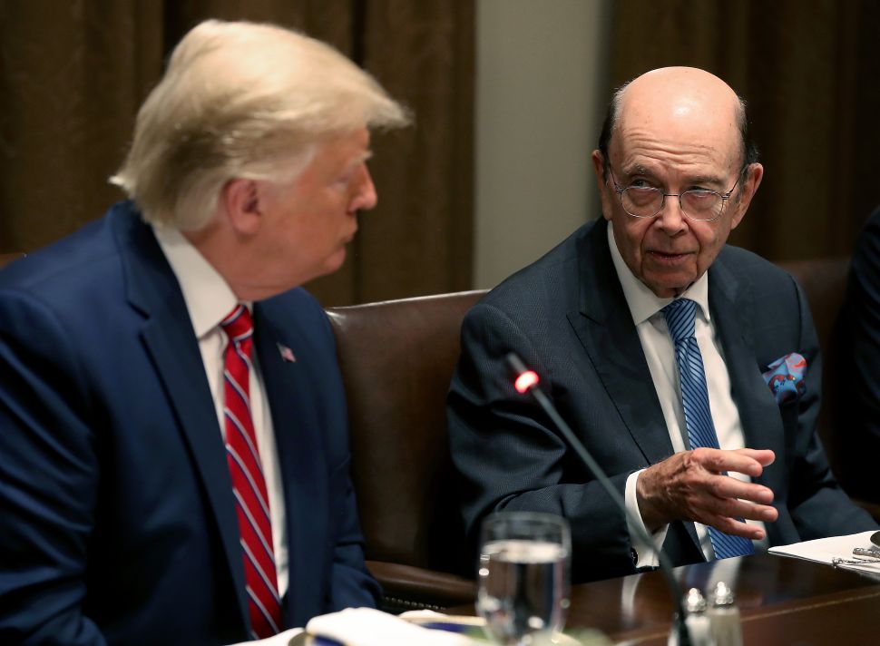President Donald Trump listens to Commerce Secretary Wilbur Ross.