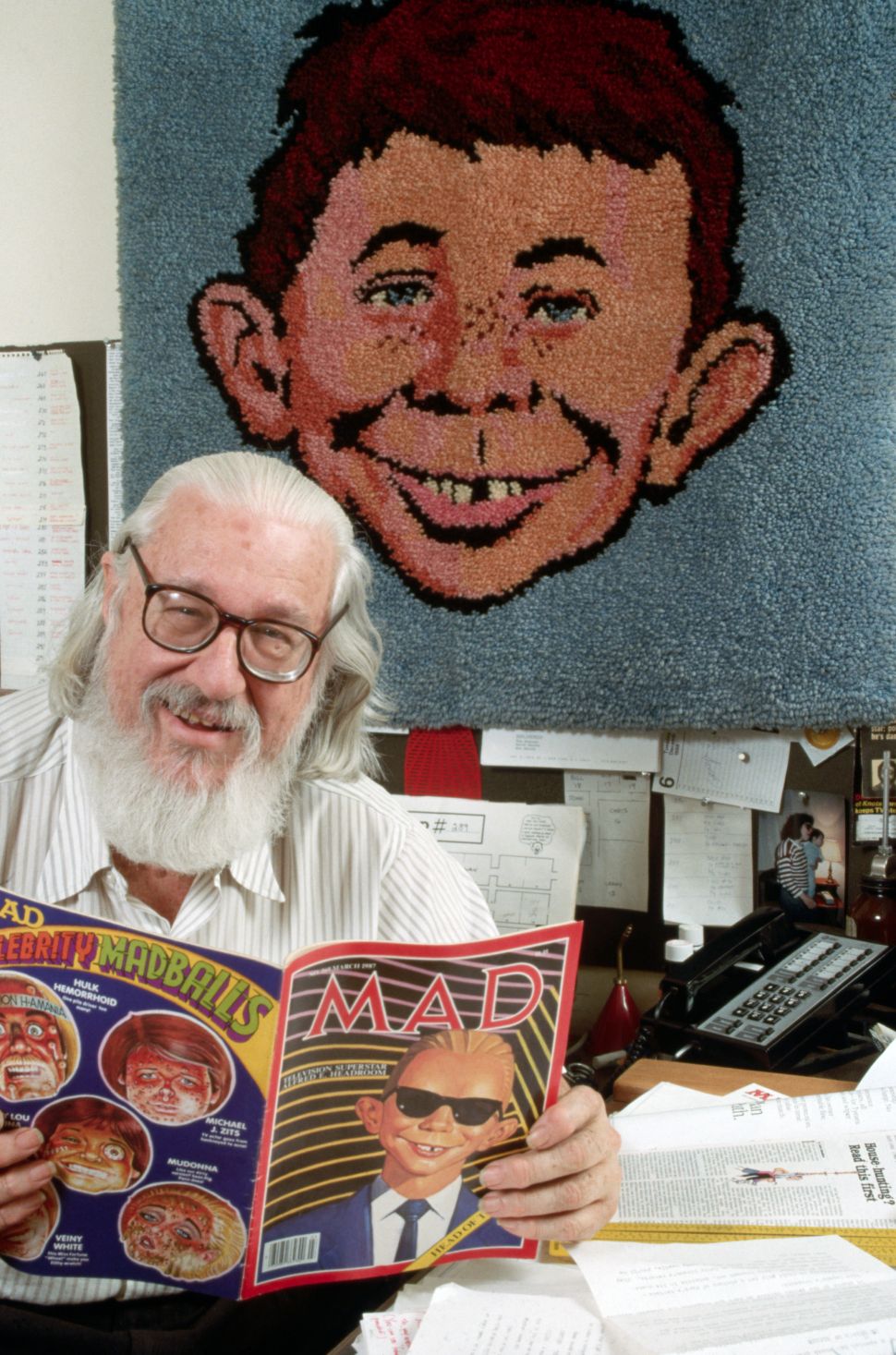 Publisher William Gaines reads a copy of Mad magazine.