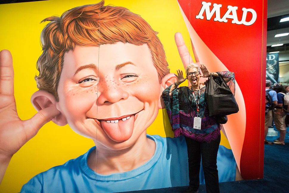 Attendee Judith Hawkins poses next to a display at the Mad magazine booth at Comic-Con Preview Night on July 20, 2016 in San Diego, California