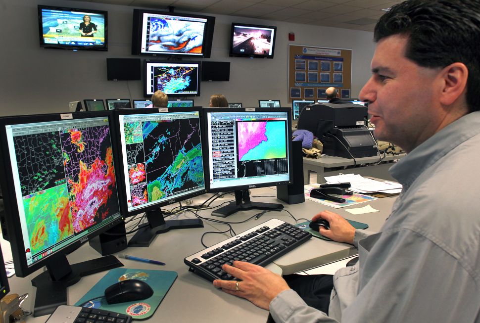 At the National Weather Service Boston Headquarters in Taunton meteorologist Joseph Dellicarpini watches over radar screens showing snow moving into southern New England around 10:30 in the morning. 