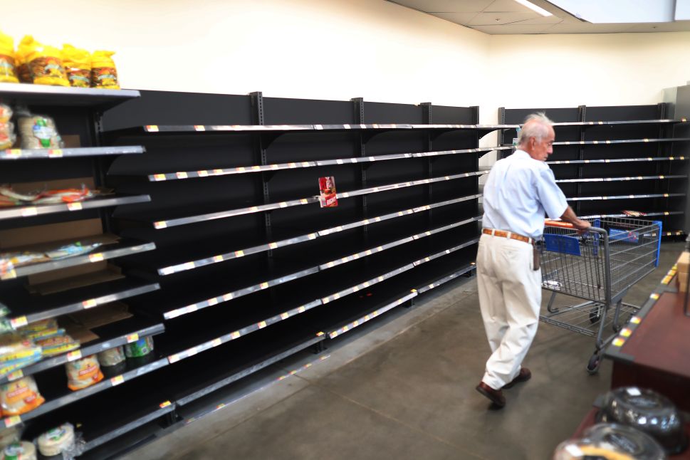 A shopper walks past the empty bread shelves in a Walmart store as people stock up before the possible arrival of Hurricane Dorian on August 30, 2019 in Boynton Beach, Florida.