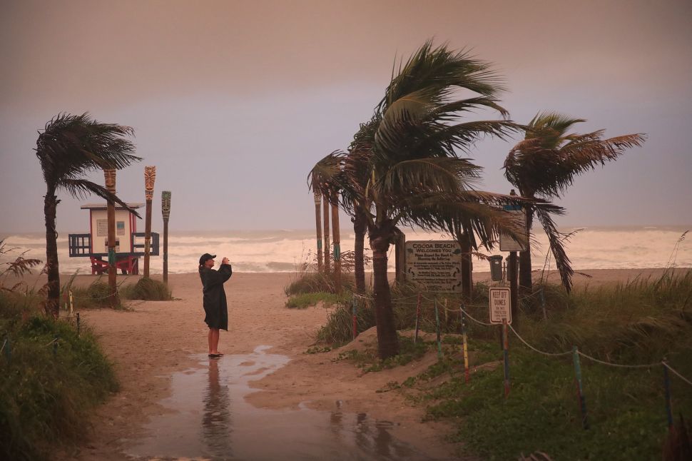 A woman takes a picture as the effects of Hurricane Dorian begin to be felt on September 2, 2019 in Cocoa Beach, Florida.