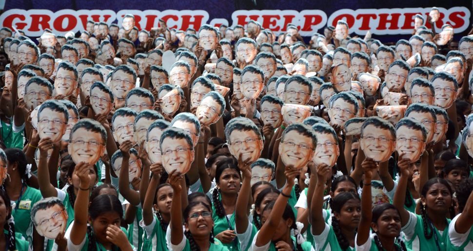 Indian schoolchildren hold masks with the face of Bill Gates.