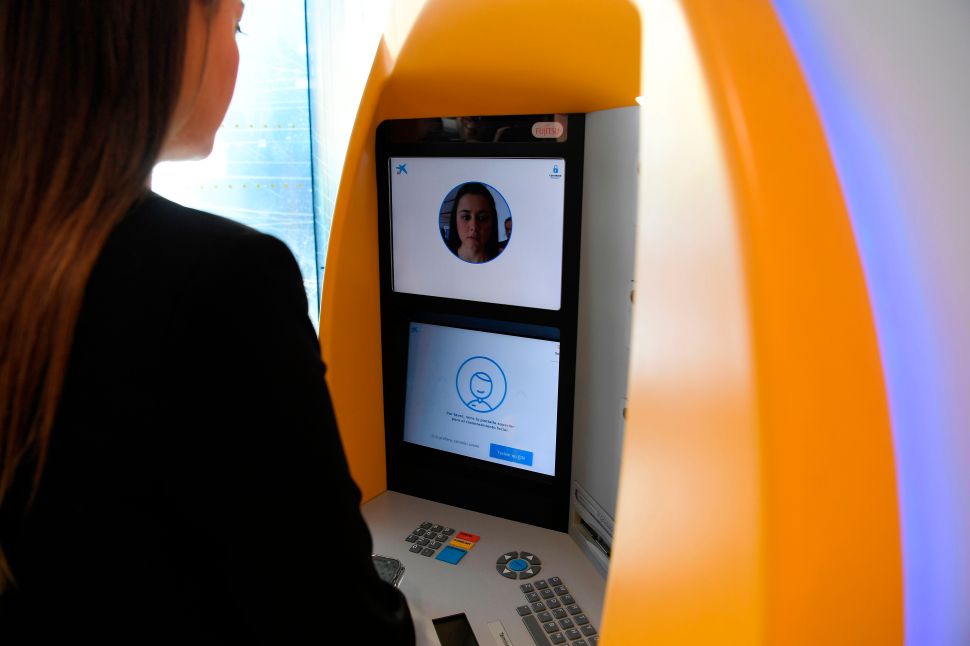 A woman uses an ATM with facial recognition technology during the presentation of the new service by CaixaBank in Barcelona on February 14, 2019.