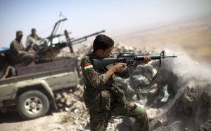 An Iraqi Kurdish Peshmerga fighter fires at Islamic-State militant positions. (JM LOPEZ/AFP/Getty Images)