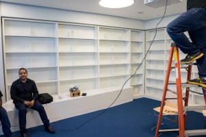 Men working on finishing details in the library (Photo: Jake Naughton).